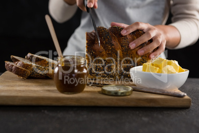 Woman cutting freshly baked multigrain bread