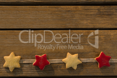 Overhead view of star shaped cookies arranged on ribbon at table