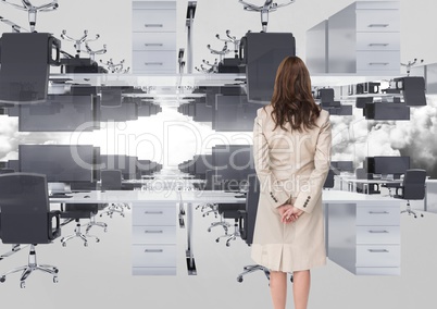 businesswoman standing in inverted office in the clouds