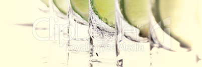 Alcoholic cocktail with lime and ice, isolated with reflection