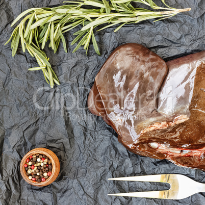 healthy fod Raw liver with rosemary on a black background