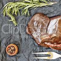 healthy fod Raw liver with rosemary on a black background