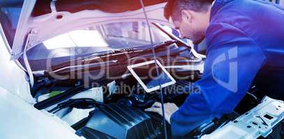 Mechanic using tablet to fix car