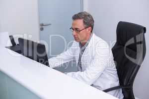 High angle view of dentist sitting by computer