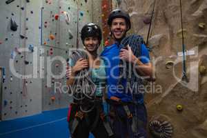 Portrait of athletes in sports helmet carrying ropes at gym