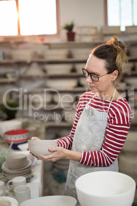 Female potter holding stack of bowls