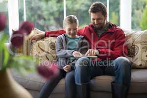Father and daughter using digital tablet