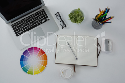 Laptop, spectacles, color swatch and stationery on white background