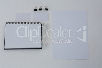 Book, paper clip, visiting cards and blank paper on white background