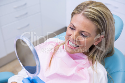 Woman looking at mirror in dental clinic