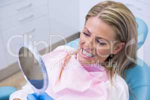 Woman looking at mirror in dental clinic