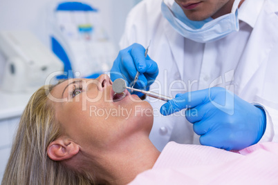 Dentist examining young woman at medical clinic