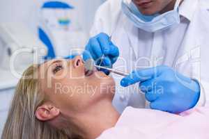 Dentist examining young woman at medical clinic