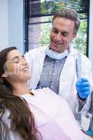 Dentist showing mirror to patient at medical clinic