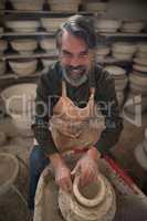 Portrait of male potter molding a clay