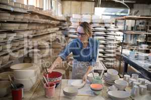 Female potter painting bowl