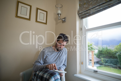 Man using digital tablet while sitting