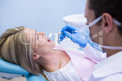 Dentist examining woman at clinic