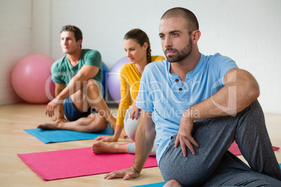 Yoga instructor guiding students in practicing Ardha Matsyendrasana