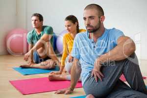 Yoga instructor guiding students in practicing Ardha Matsyendrasana