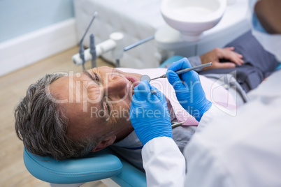 High angle view of dentist examining senior man