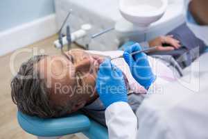 High angle view of dentist examining senior man