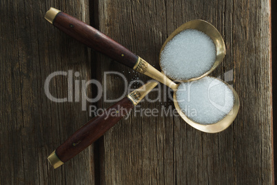 Salt in spoon on wooden table