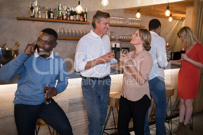 Friends interacting while having drinks at counter