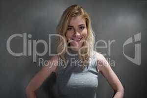 Portrait of beautiful woman smiling against grey background