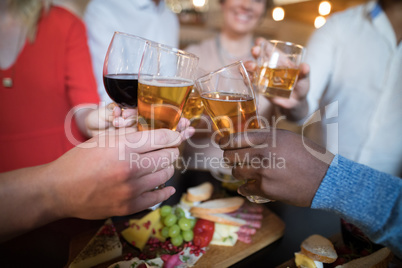 Close-up of friends toasting drinks
