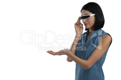 Female executive gesturing while using virtual reality headset