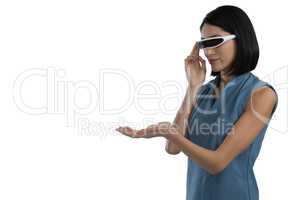 Female executive gesturing while using virtual reality headset