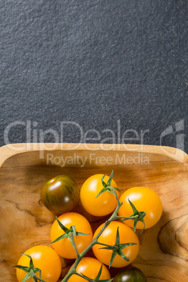 Overhead view of cherry tomatoes in wooden plate
