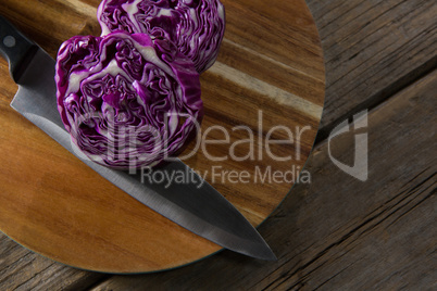 Red cabbage with knife on chopping board