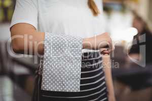 Midsection of waitress with napkin on arm