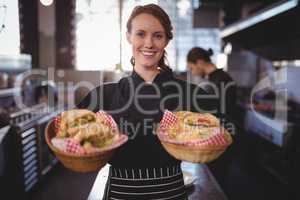 Portrait of smiling waitress serving fresh burgers at coffee shop