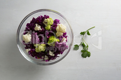 Overhead view of cauliflowers and red cabbages in bowl