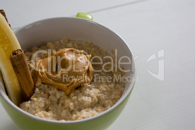 Cup of oats with peanut butter and cinnamon sticks