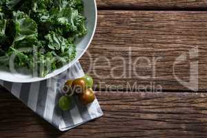Mustard greens and gooseberry on wooden table