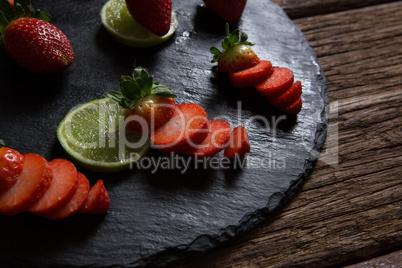 Sliced strawberries and lemon on round tray