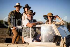 Portrait of happy friends enjoying in vehicle during safari vacation