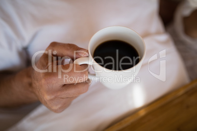 Mid section of man having black coffee