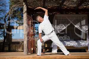 Man practicing yoga in cottage