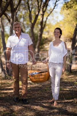 Smiling couple holding a wicker basket during safari vacation