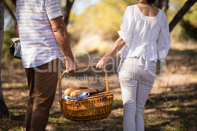 Mid-section of couple holding a wicker basket