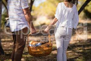 Mid-section of couple holding a wicker basket