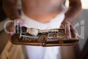 Mid-section of man holding shaving kit