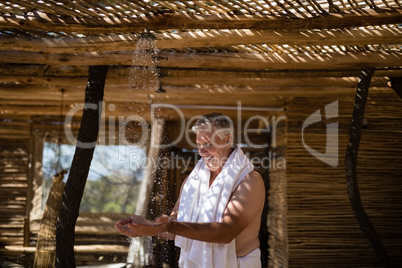 Man washing hands from shower in cottage during safari vacation