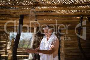 Man washing hands from shower in cottage during safari vacation