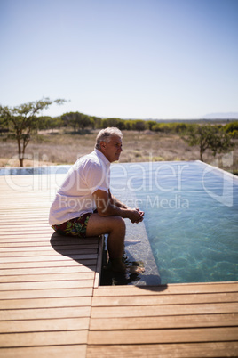 Thoughtful man sitting near pool side